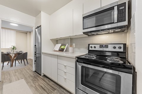A modern kitchen with a stove, oven, refrigerator, and microwave.
